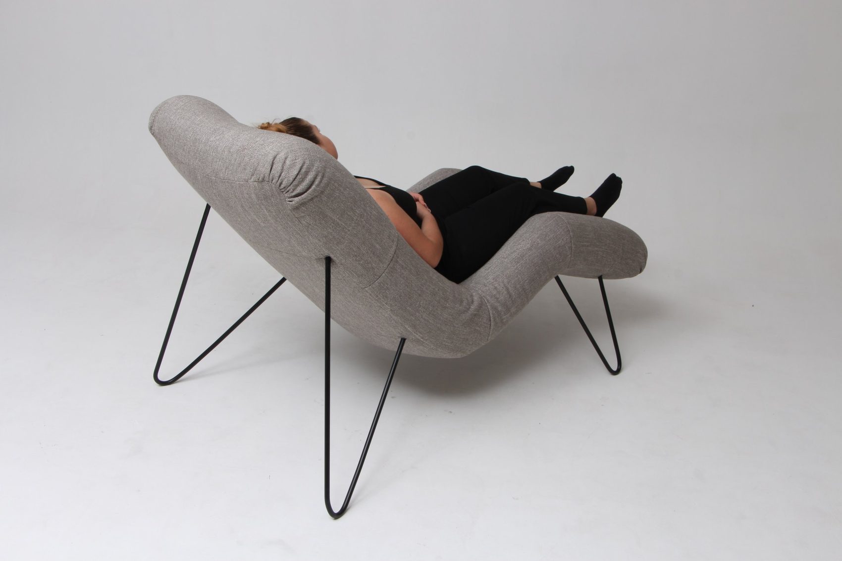 Une personne allongée sur l’assise CAP’EMI, vue de dos : la garniture épouse son corps de la tête aux pieds